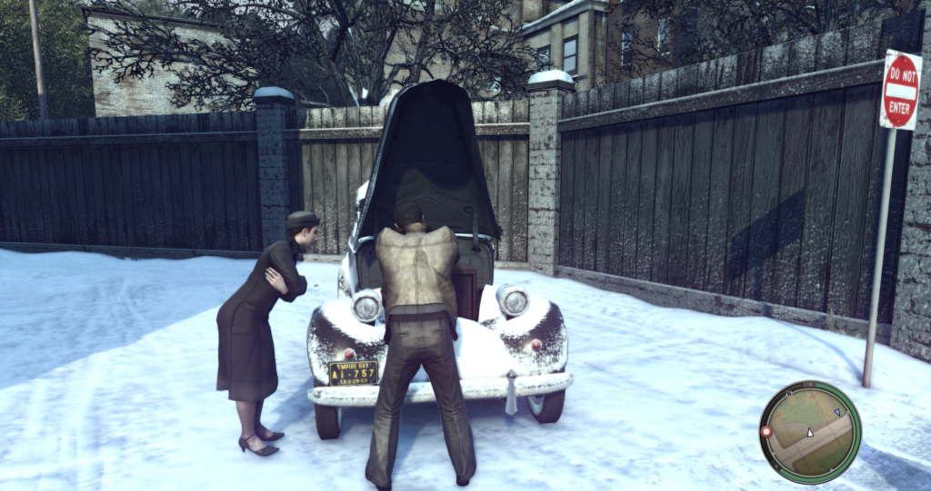 Мужчина чинит машину с открытым капотом на снегу