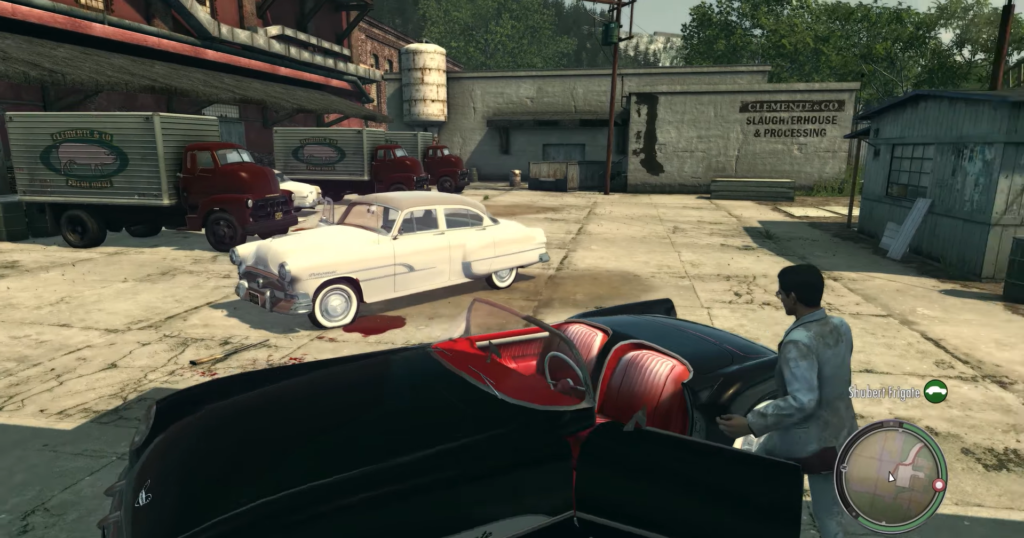 Мужчина садится в чёрный кабриолет на заводском дворе