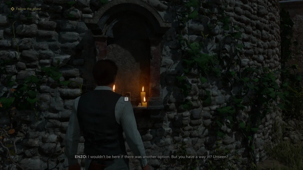 Энцо стоит у свечей в каменной нише A Plague Tale: Requiem