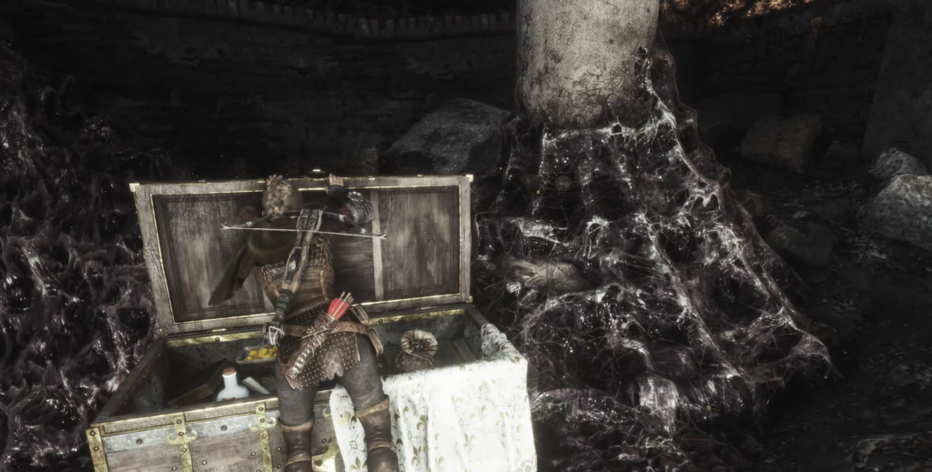 Персонаж Skyrim обыскивает сундук в пещере с паутиной